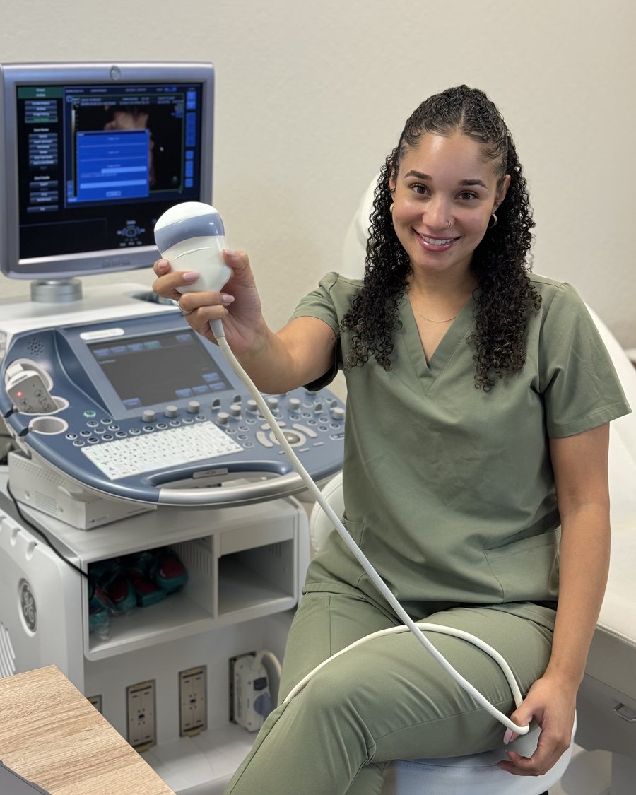 Ericka, owner of Sweet 3D Baby, seated at the ultrasound machine holding a transducer.